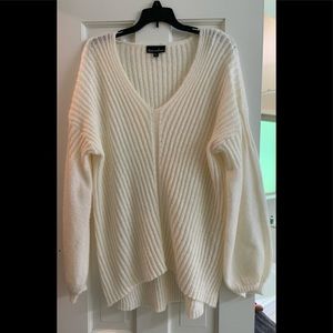 Light cream sweater with a longer back. Not heavy
